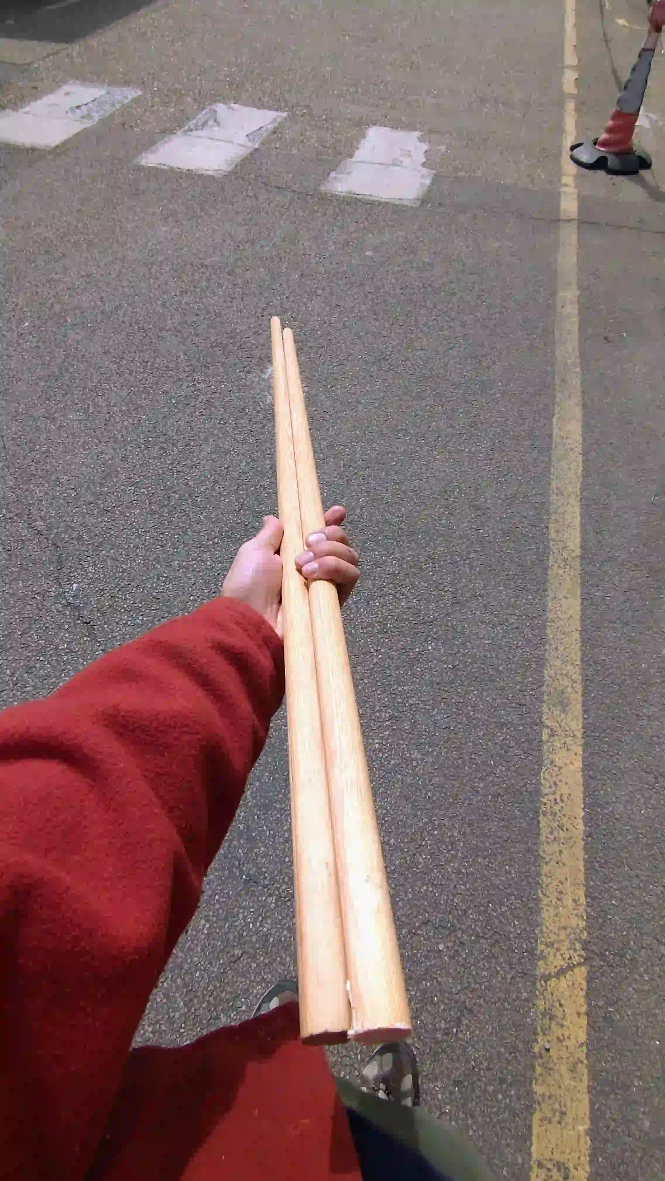 Person holding two wooden dowel sticks