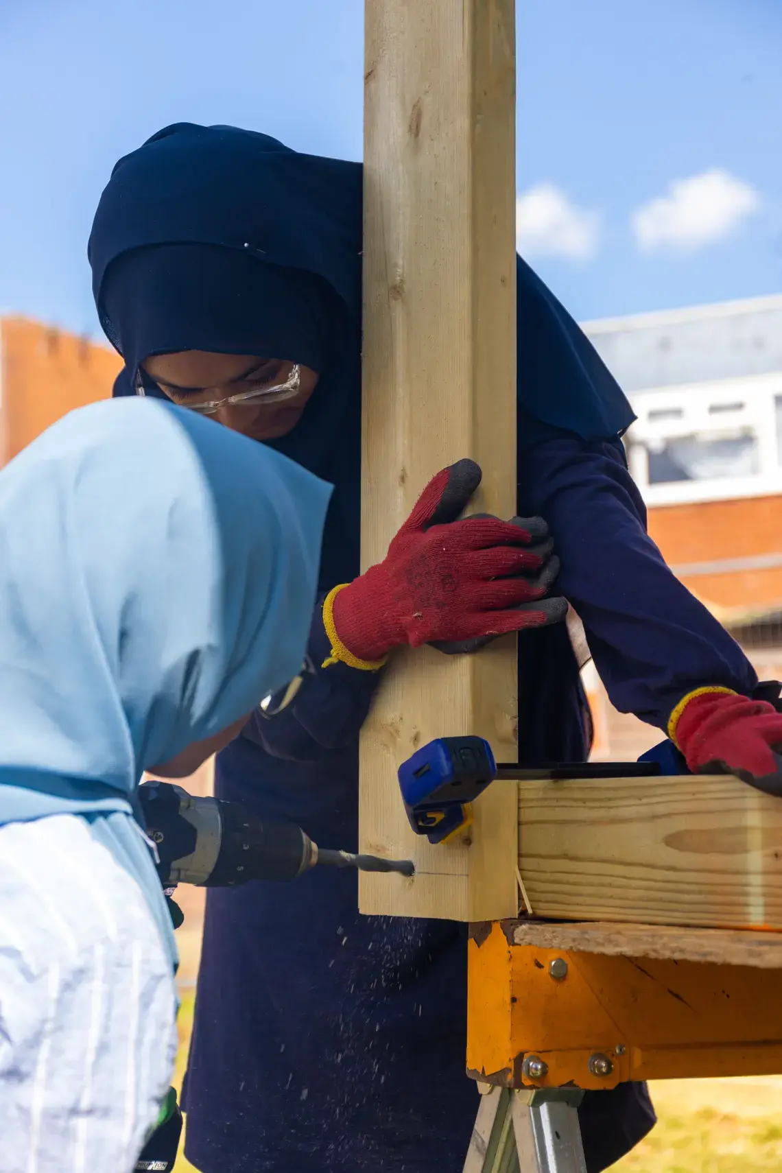 Young people screwing a wooden structure