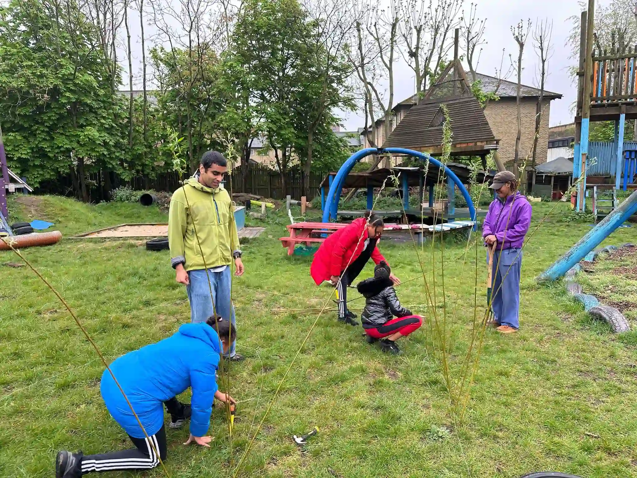 Willow tunnel being built at Pearson Street Adventure Playground with local children and adults