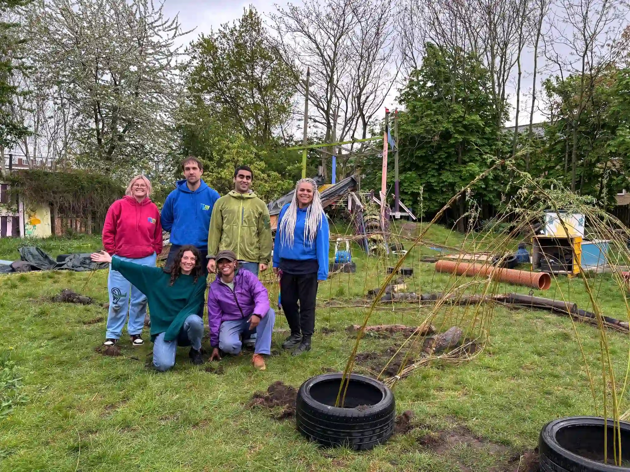Community members weaving willow branches to create the tunnel structure